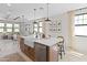 Open-concept kitchen with a large island, stainless steel appliances and a breakfast bar overlooking the living room at 20332 W Sells Dr, Buckeye, AZ 85396