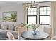 Bright living room area featuring a comfortable sofa, neutral colors, and modern lighting with a view to the outside at 20332 W Sells Dr, Buckeye, AZ 85396