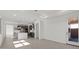 Bright open-concept living room featuring modern tile flooring and seamlessly connected to a sleek, contemporary kitchen at 20332 W Sells Dr, Buckeye, AZ 85396