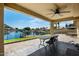 Covered back patio with a table and chairs, perfect for outdoor entertaining with a view of the lake at 20713 N 56Th Ave, Glendale, AZ 85308