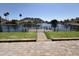 Backyard overlooking waterfront featuring a brick patio, green turf, and wrought iron fence at 20713 N 56Th Ave, Glendale, AZ 85308
