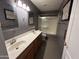 Full bathroom with dual sinks, dark gray walls and shower-tub combo at 20713 N 56Th Ave, Glendale, AZ 85308