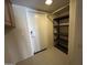 Hallway with tile flooring, cabinets, closet shelves, and a security door at 20713 N 56Th Ave, Glendale, AZ 85308
