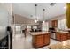 Spacious kitchen featuring granite countertops, a central island, and views into the dining and living areas at 20713 N 56Th Ave, Glendale, AZ 85308