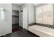 Bathroom featuring a soaking tub with tile surround and a walk-in closet at 20713 N 56Th Ave, Glendale, AZ 85308