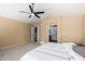 Spacious primary bedroom featuring a ceiling fan, neutral carpet, and a door to the ensuite bathroom at 20713 N 56Th Ave, Glendale, AZ 85308