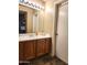 Bathroom with wood vanity, single sink, and a large mirror at 2397 E Winchester Pl, Chandler, AZ 85286