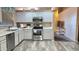 Bright kitchen with stainless steel appliances, white cabinetry, and wood-look flooring at 2397 E Winchester Pl, Chandler, AZ 85286