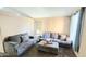 Cozy living area showcasing dual sofas, a large ottoman, and a bright window with natural light at 2397 E Winchester Pl, Chandler, AZ 85286