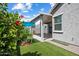 Landscaped backyard featuring artificial grass, mature trees and access to covered patio at 2644 S Dock St, Gilbert, AZ 85295