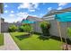 Spacious backyard featuring artificial grass, mature trees, and a well-maintained block wall at 2644 S Dock St, Gilbert, AZ 85295