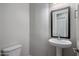 Powder room with a pedestal sink, dark framed mirror, and neutral walls at 2644 S Dock St, Gilbert, AZ 85295
