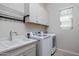 Functional laundry room with modern washer and dryer and a utility sink at 2644 S Dock St, Gilbert, AZ 85295