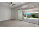 Neutral living area with modern ceiling fan and sliding doors to outdoor patio and backyard at 2644 S Dock St, Gilbert, AZ 85295