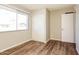 Bedroom with hardwood flooring, a window, and a closet, with a door at 3045 W Palmaire Ave, Phoenix, AZ 85051