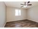 An empty bedroom featuring hardwood floors, a ceiling fan, and a window with blinds at 3045 W Palmaire Ave, Phoenix, AZ 85051