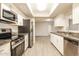 Modern kitchen with stainless steel appliances, granite counters, and white cabinets, open to living area at 3045 W Palmaire Ave, Phoenix, AZ 85051
