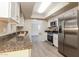 Updated kitchen featuring granite countertops, stainless steel appliances, and stylish white cabinetry at 3045 W Palmaire Ave, Phoenix, AZ 85051