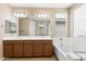 Bright bathroom with double sinks, soaking tub, walk-in shower, and large vanity mirror at 3072 E Appaloosa Rd, Gilbert, AZ 85296