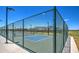 Outdoor pickleball court featuring a green surface, sturdy fencing, and bright overhead lighting at 3072 E Appaloosa Rd, Gilbert, AZ 85296