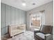 Charming Bedroom featuring a crib, accent wall, a comfortable glider chair and window view to backyard at 3114 S Eugene --, Mesa, AZ 85212
