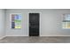 Inviting entryway with wood-look tile flooring, black door, and natural lighting at 3601 N 12Th St, Phoenix, AZ 85014