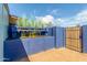Landscaped backyard featuring a vibrant blue fence with decorative plants, offering privacy and style at 3645 N 69Th Ave # 12, Phoenix, AZ 85033