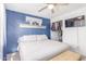 Comfortable bedroom with blue accent wall, decorative shelf, TV, and closet access at 3645 N 69Th Ave # 12, Phoenix, AZ 85033