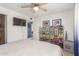 Bright bedroom featuring TV, fan, and extensive shoe collection on metal shelves at 3645 N 69Th Ave # 12, Phoenix, AZ 85033