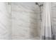 Shower featuring elegant white marble tile with decorative glass accents at 3645 N 69Th Ave # 12, Phoenix, AZ 85033