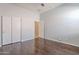 A bedroom with hardwood floors, a ceiling fan, and a closet for plenty of storage space at 514 E Pearce Rd, Phoenix, AZ 85042