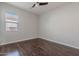 An empty bedroom with dark hardwood floors and a window providing ample natural light at 514 E Pearce Rd, Phoenix, AZ 85042