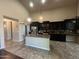 A kitchen boasts an island with granite countertops, stainless appliances, black cabinets, and modern pendant lighting at 514 E Pearce Rd, Phoenix, AZ 85042