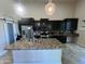A spacious kitchen features a large island with granite countertops, stainless steel appliances, and ample cabinet space at 514 E Pearce Rd, Phoenix, AZ 85042
