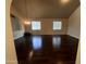 Open living space featuring dark wood floors, modern lighting, and two windows, creating a versatile area at 514 E Pearce Rd, Phoenix, AZ 85042