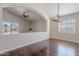 Cozy living room featuring hardwood floors, neutral paint, vaulted ceilings, and a view into the kitchen area at 514 E Pearce Rd, Phoenix, AZ 85042
