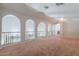 Large open loft space featuring decorative arches, wrought iron railing, and neutral carpeting at 514 E Pearce Rd, Phoenix, AZ 85042