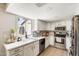 Bright kitchen features stainless steel appliances, white cabinetry, and a marble-look countertop at 5350 N 3Rd Ave, Phoenix, AZ 85013