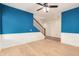Well-lit bedroom with blue accent walls, white trim, hardwood floors and a ceiling fan at 5423 W Range Mule Dr, Phoenix, AZ 85083