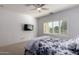 Bedroom featuring carpet floors, ceiling fan and a TV on the wall at 5423 W Range Mule Dr, Phoenix, AZ 85083