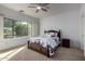 Comfortable bedroom featuring a large window, ceiling fan, and classic wooden furnishings at 5423 W Range Mule Dr, Phoenix, AZ 85083