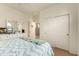 Bedroom featuring a large dresser, white closet doors, and a cozy bed at 5423 W Range Mule Dr, Phoenix, AZ 85083