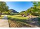 Community greenbelt featuring walking path, lush lawn, mature trees and mountain views at 5423 W Range Mule Dr, Phoenix, AZ 85083