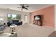 Open living room featuring neutral color carpet, a TV and an access door to the back yard at 5423 W Range Mule Dr, Phoenix, AZ 85083
