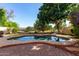 Inviting backyard pool area with brick pavers and mature foliage for privacy at 5423 W Range Mule Dr, Phoenix, AZ 85083