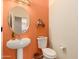 Bright powder room with a pedestal sink, decorative wall, and round mirror at 5423 W Range Mule Dr, Phoenix, AZ 85083