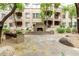 Condo community courtyard featuring stone fireplace, mature trees, benches, and lovely landscaping at 5450 E Deer Valley Dr # 3003, Phoenix, AZ 85054