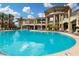 Gorgeous community pool with lounge chairs, palm trees, and a beautiful building in the background at 5450 E Deer Valley Dr # 3003, Phoenix, AZ 85054