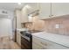 Well-equipped kitchen with stainless steel appliances, light countertops, and tile backsplash at 6111 N 8Th St, Phoenix, AZ 85014