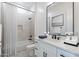Bright bathroom with a framed mirror, large vanity, and bathtub with shower at 6514 W Apex Ave, Queen Creek, AZ 85144
